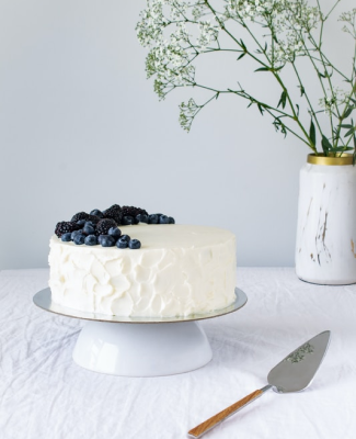 Blueberry topped cake next to a vase